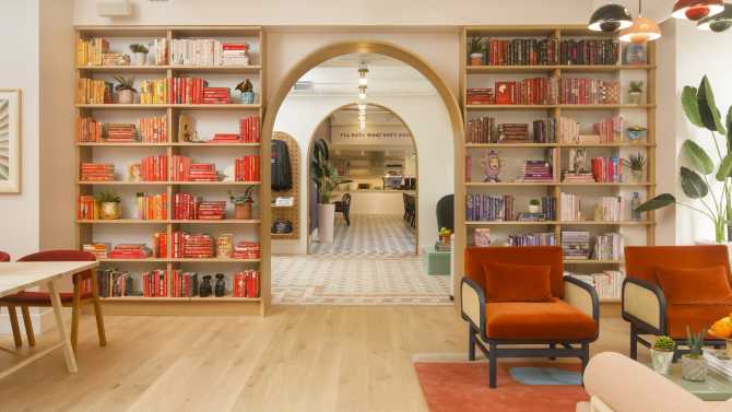 Library with various colors on the bookshelf. Long hallway with arched doorways.