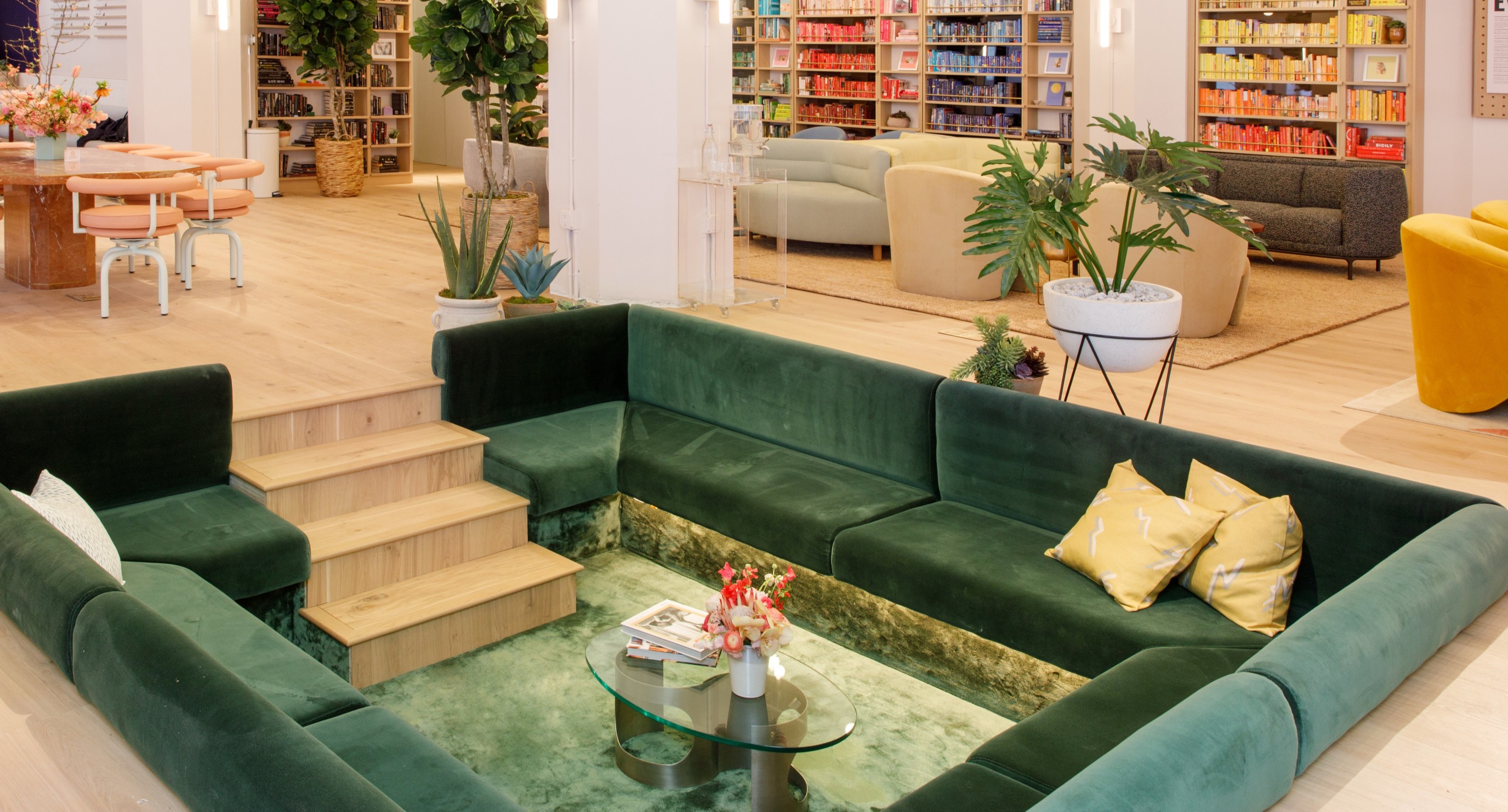 Light-filled room with green velvet sunken couch.