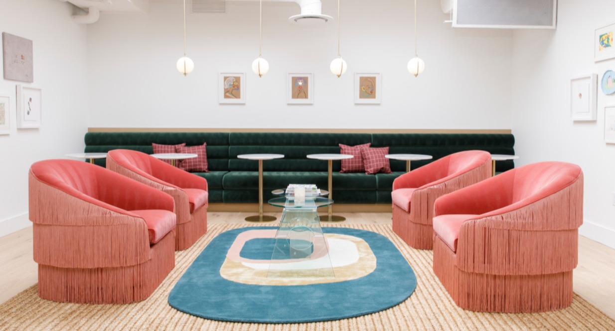 Four deep pink chairs in a room with a large roof window.