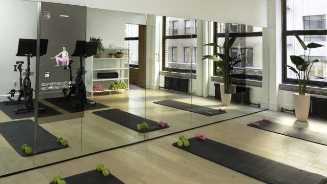 Image of fitness room with yoga mats, mirrors, and cycling bikes