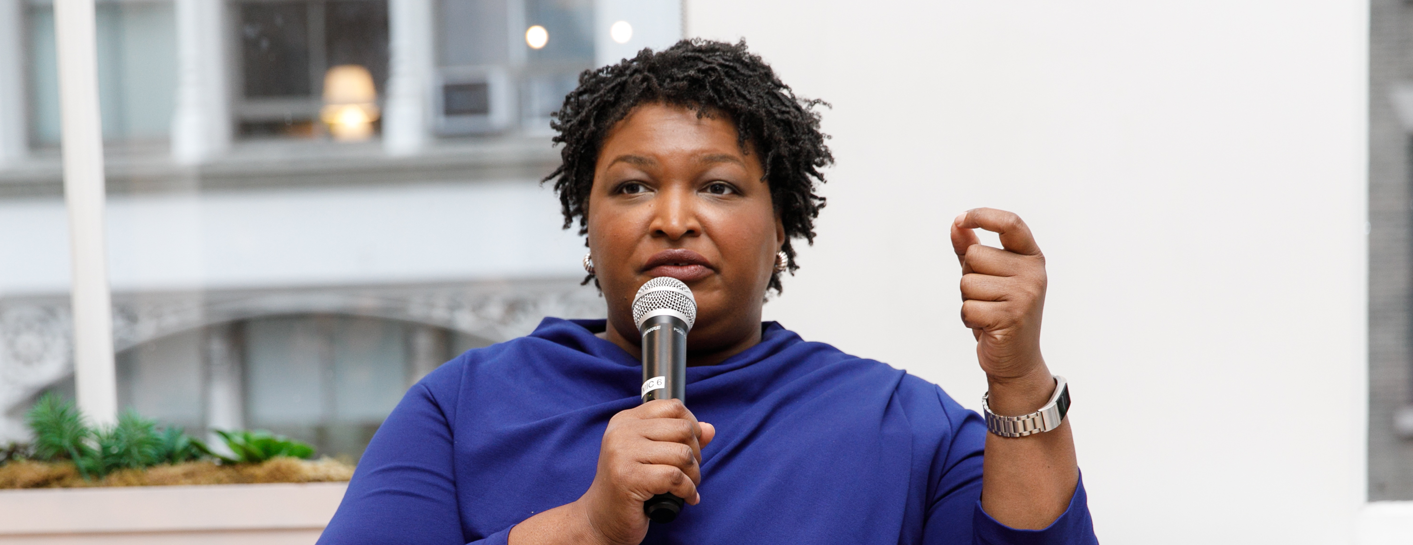 Stacey Abrams speaking and holding a microphone